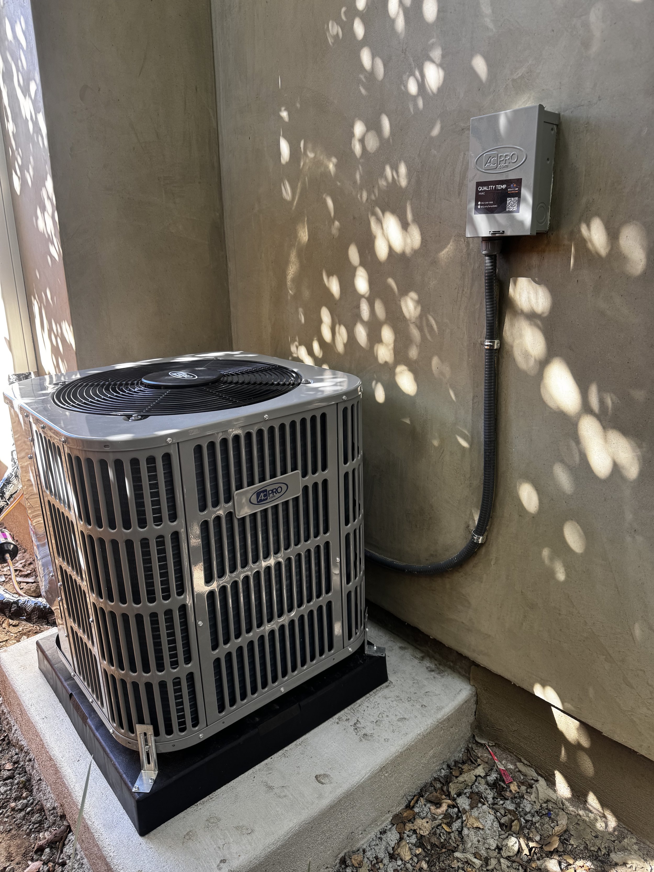 Outdoor air conditioning condenser installed beside a stucco home