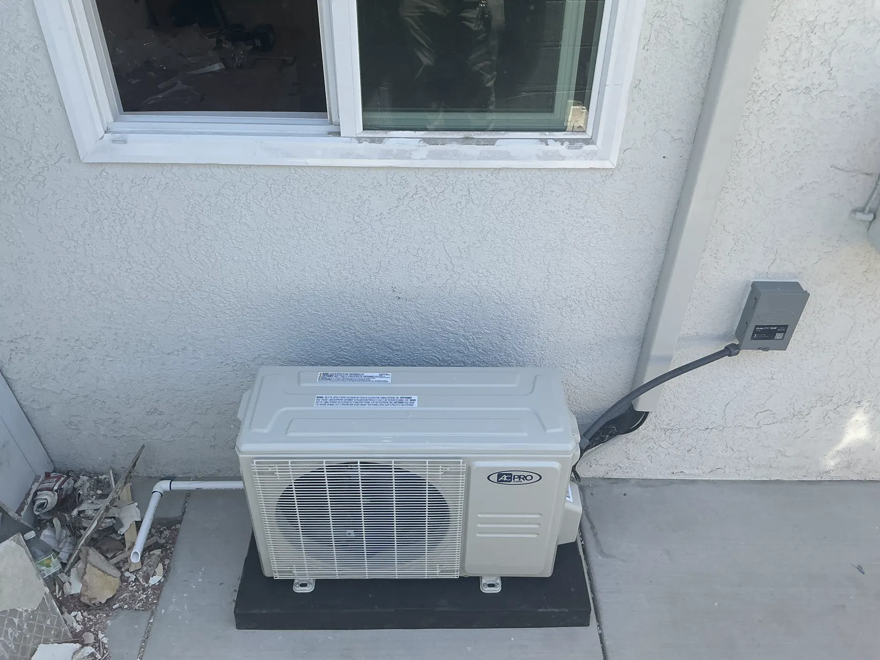 Outdoor HVAC unit beside a wall